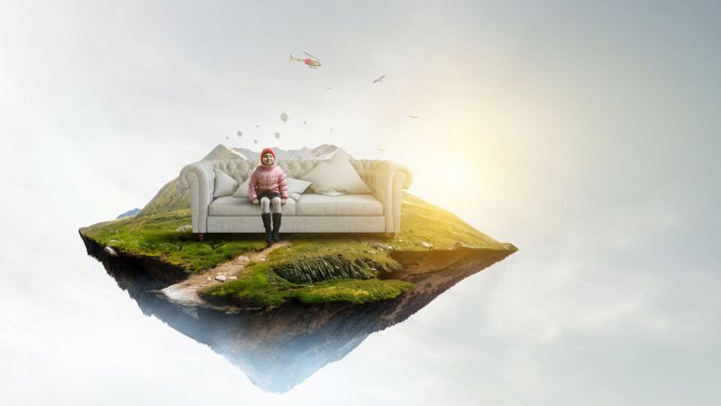 Immagine a specchio di un’isola nordica su sfondo di luce bianco con mongolfiere ed elicottero; una bambina con espressione sognante siede su un sofà chiaro