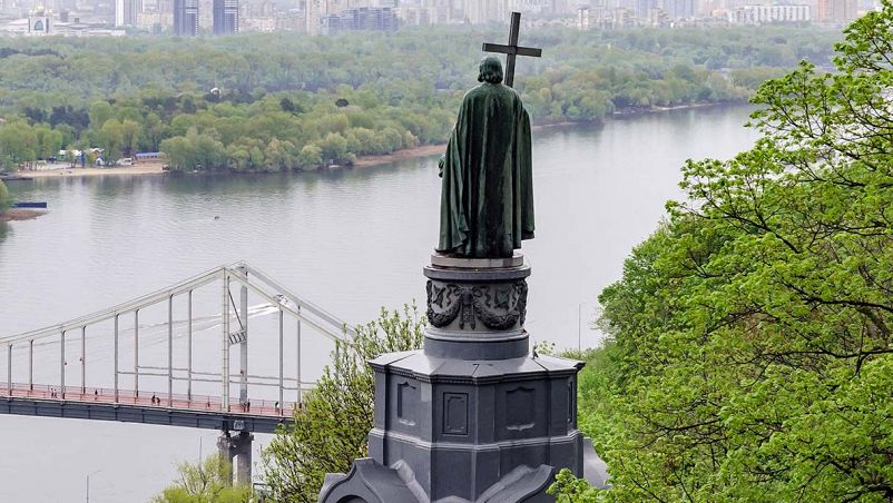 La statua di un santo davanti a un fiume