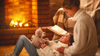 Una mamma e una figlia di 5 anni distese a terra a leggere