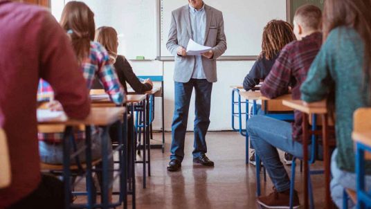 Professore in classe con le verifiche