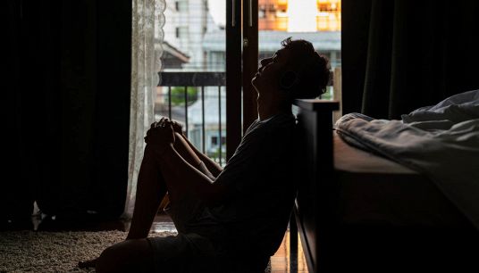 Ragazzo seduto in camera da solo