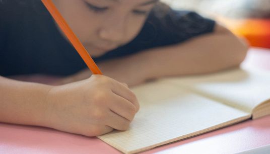 Bambino alle prese con i compiti delle vacanze estive