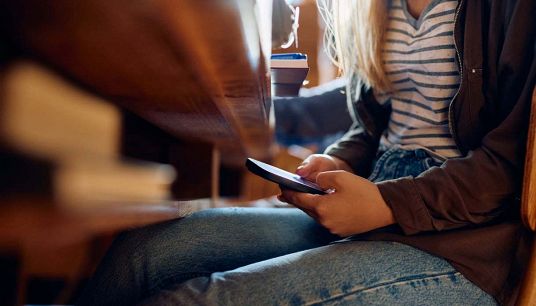 Ragazza usa lo smartphone in classe