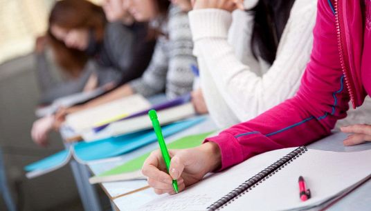 Studenti e studentesse scrivono in classe