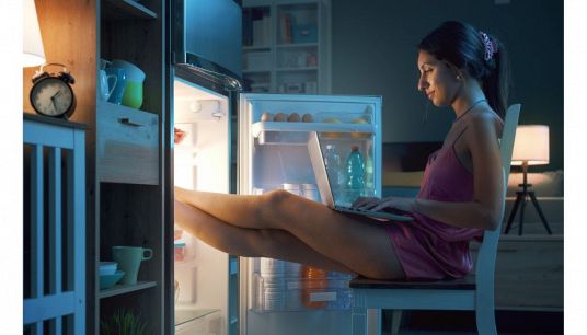 ragazza con pc davanti al frigo