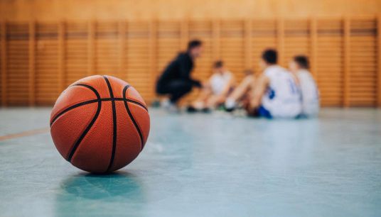Ragazzi a lezione di basket in palestra
