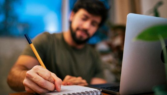 ragazzo scrive a mano su foglio