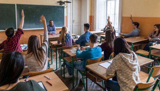 Ragazzi alzano la mano per partecipare alla lezione