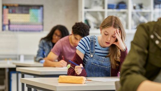 Ragazza che scrive un compito in classe