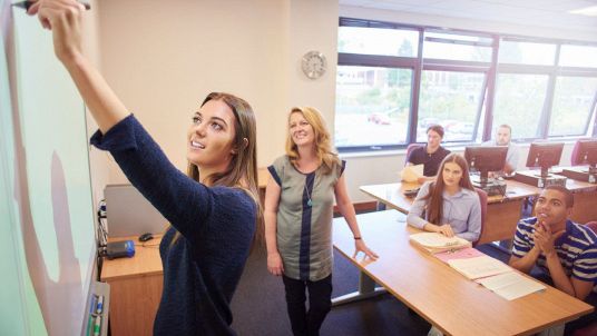 studente scrive su lavagna interattiva in classe