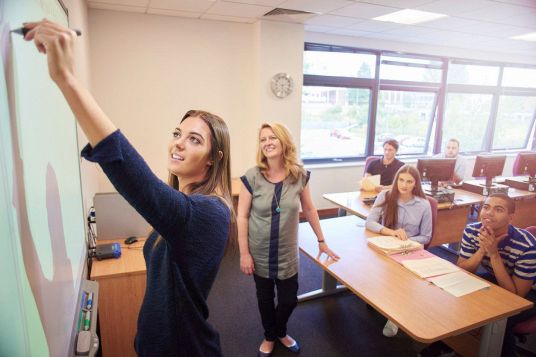studente scrive su lavagna interattiva in classe