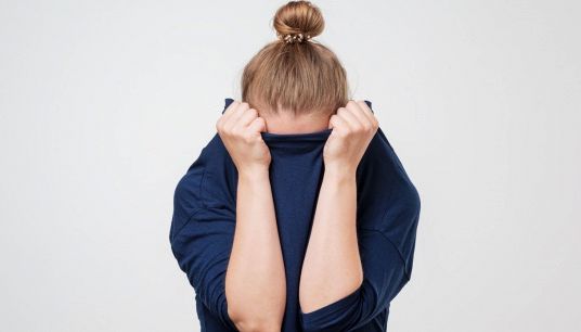 ragazza si copre il volto per la timidezza