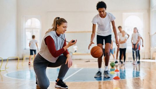 Insegnante con alunno in palestra durante attività fisica