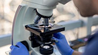 Scienziato al microscopio
