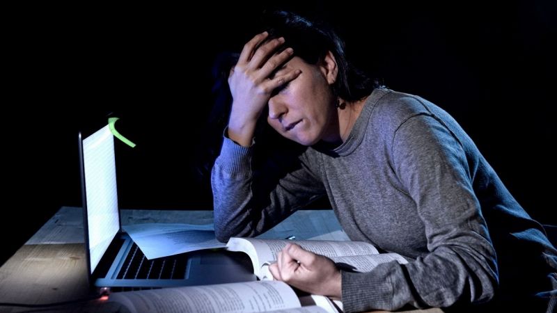 ragazza molto stanca mentre studia di notte