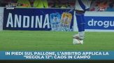 In piedi sul pallone, l'arbitro applica la "Regola 12": caos in campo