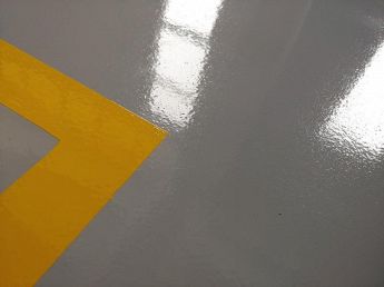 Dettaglio pavimentazione industriale in magazzino con segnaletica