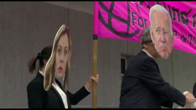 Le maschere di Biden e Meloni: manifestazione davanti a World Bank