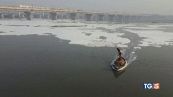 Fiume sacro indiano tra schiuma e rifiuti